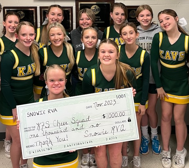 School cheer squad holding oversided donation check for $1,000