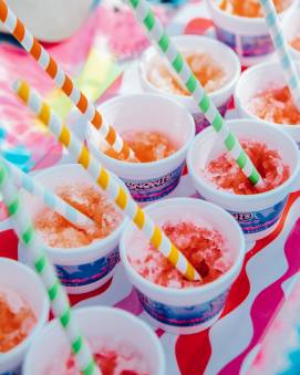 Cups of colorful shaved ice with straws