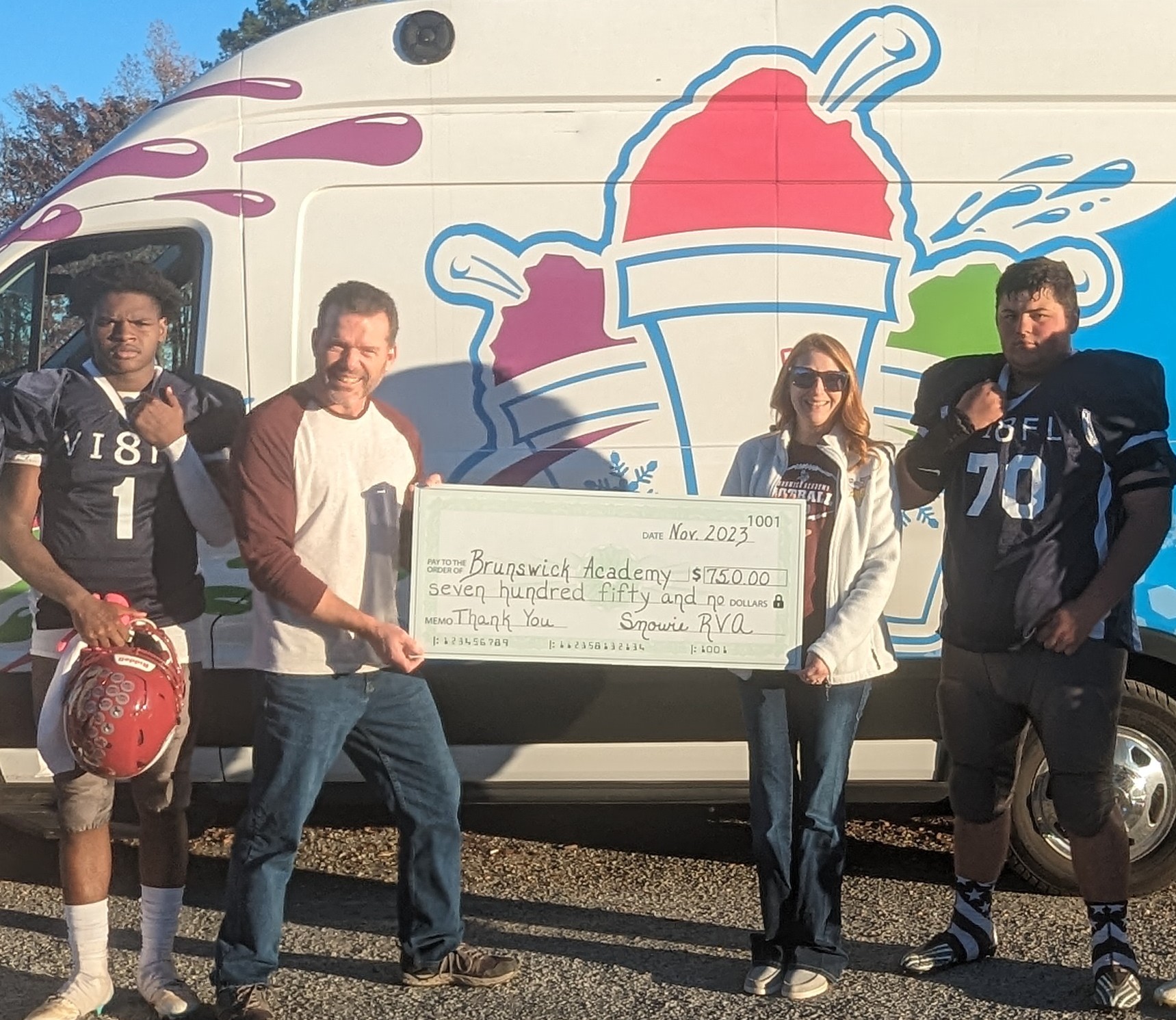 Snowie RVA, football players, and school admin holding an oversized donation check for $750