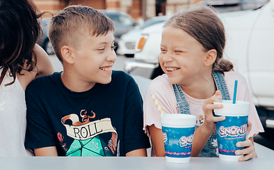 Two children laughing, enjoying an event at Snowie shaved ice